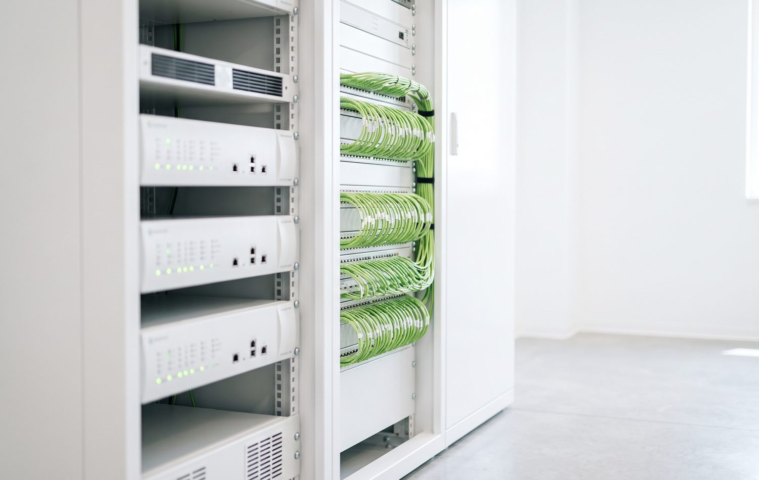 Equipment racks with neatly dressed green patch cabling